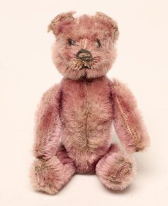 A Schuco perfume bottle bear with pink purple mohair