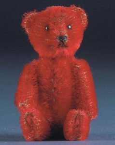 A Schuco perfume bottle bear with red mohair