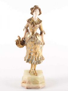 Georges Omerth a patinated bronze and ivory figure of a lady wearing a bonnet and holding a tied cloth basket numbered 7094
