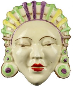 A Clarice Cliff Marlene wall mask with headdress in yellow green purple and brown