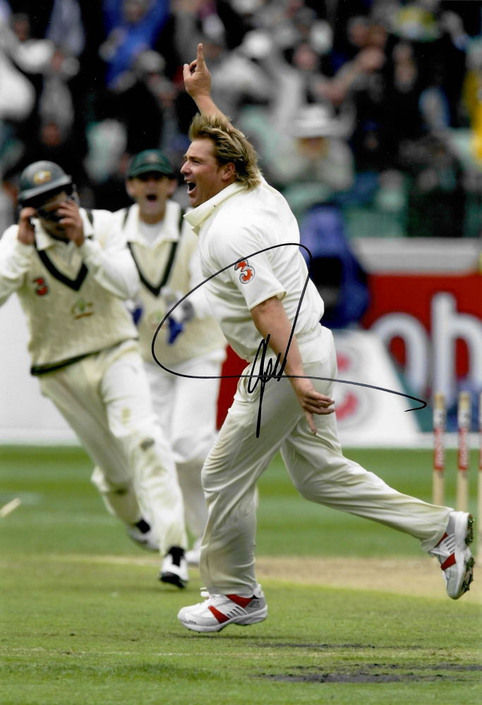 Shane Warne hand signed action photograph, taking his 700th Test Wicket at the MCG v England