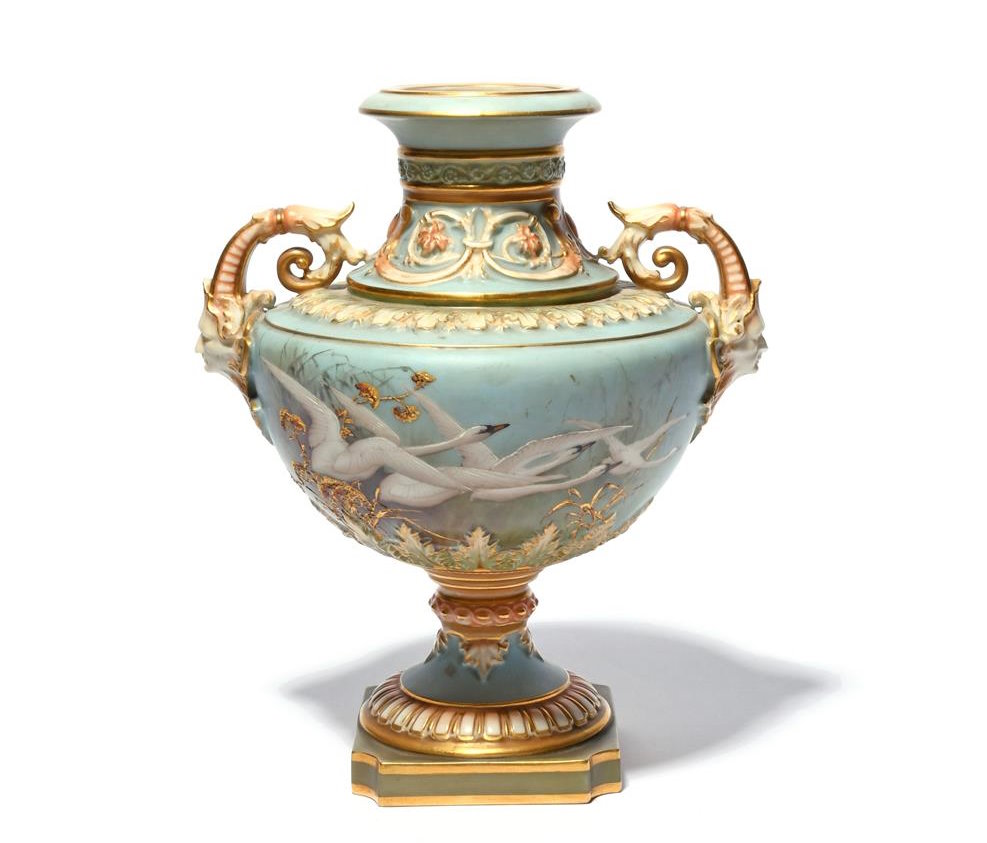 A Royal Worcester vase painted by Charles Baldwyn with four swans in flight amongst reeds and gilded seedheads on a sky blue ground