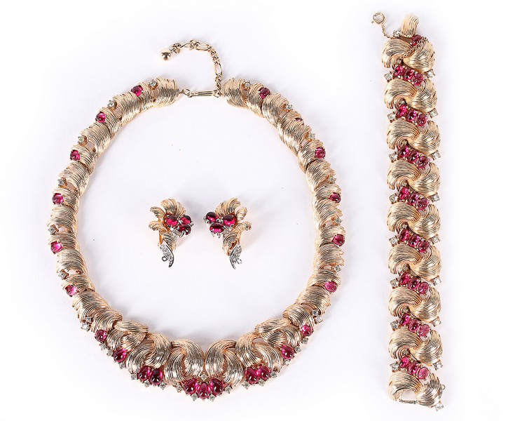 A Marcel Boucher demi-parure necklace, 1950s, comprising articulated cast gilt necklace, bracelet and ear-rings set with faux cabochon rubies and diamant